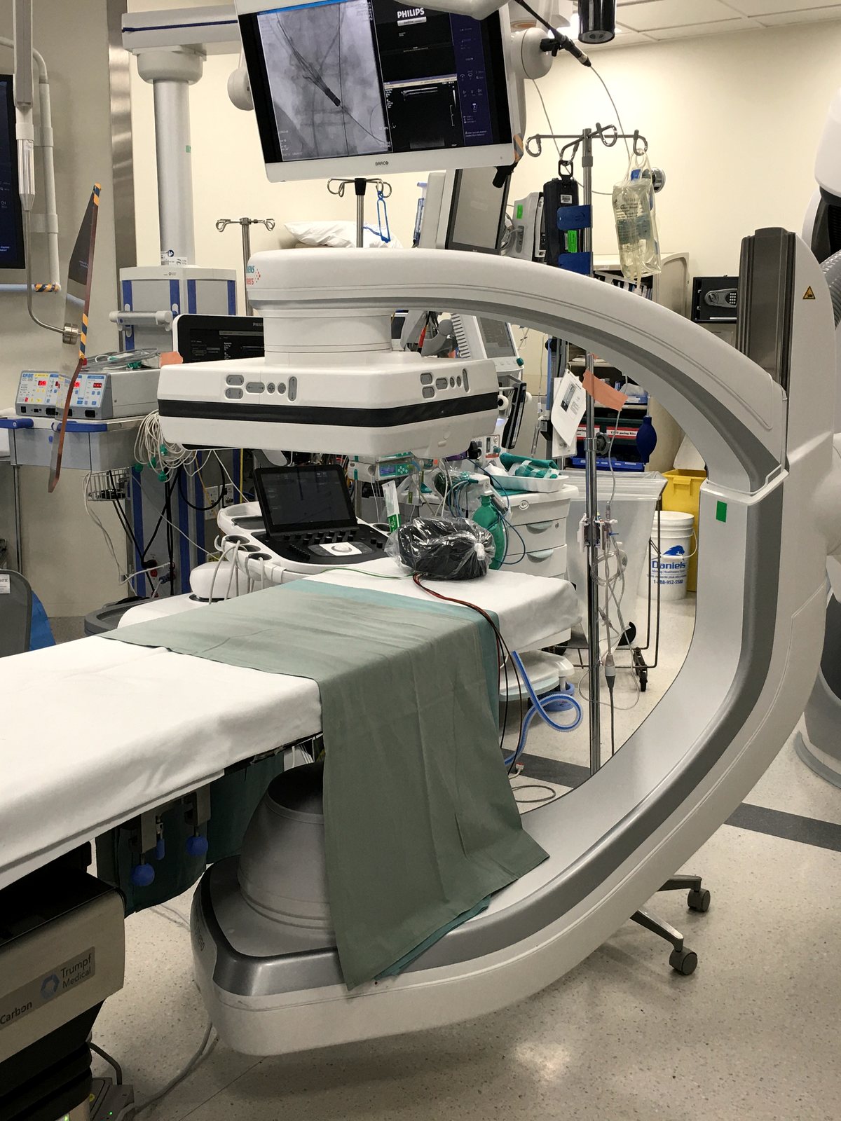 Sala cirúrgica híbrida com arco de angiografia e mesa cirúrgica